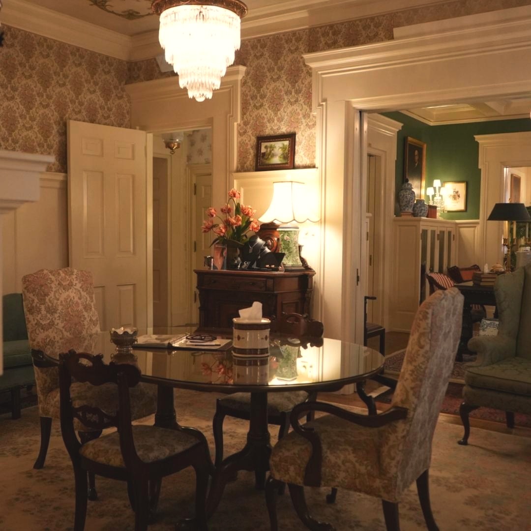 An ornate sitting room with wallpapered walls, a crystal chandelier, and antique dark-wood furniture inside Andrew K. Coffman Funeral Home in Hagerstown, Maryland.
