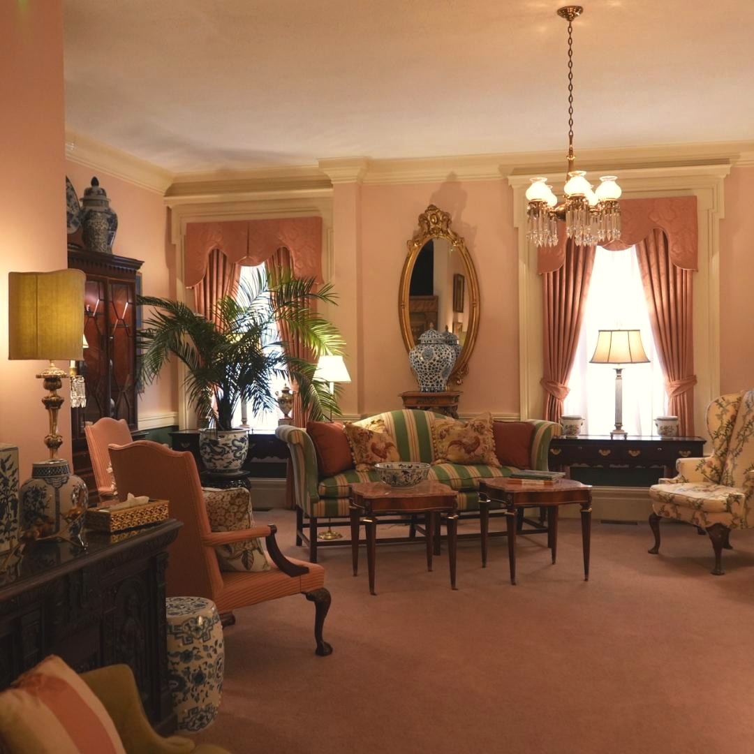 A formal sitting room in dusty rose and cream tones with a crystal chandelier and floral accents inside Andrew K. Coffman Funeral Home in Hagerstown, Maryland.