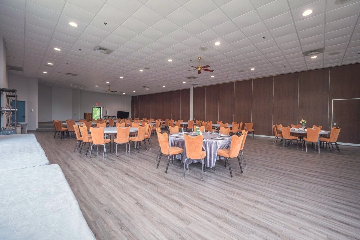 An on-site reception room at Grace Funeral & Cremation Services set with round tables and chairs for a post-service gathering.