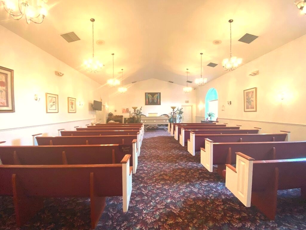 The formal brick foyer entrance at Weston's Mortuary with a chandelier and stained-glass double doors.