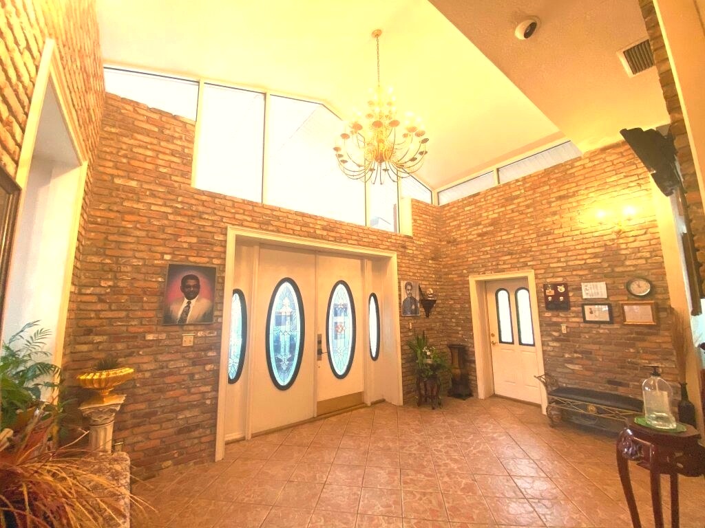 Conference-style arrangement room at Weston's Mortuary with an oval table, red upholstered chairs, and shelving displaying urns